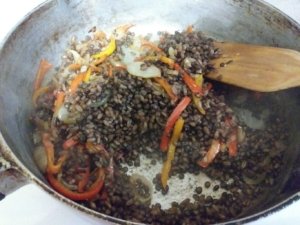 Mixing pepper and onions with lentil and farro